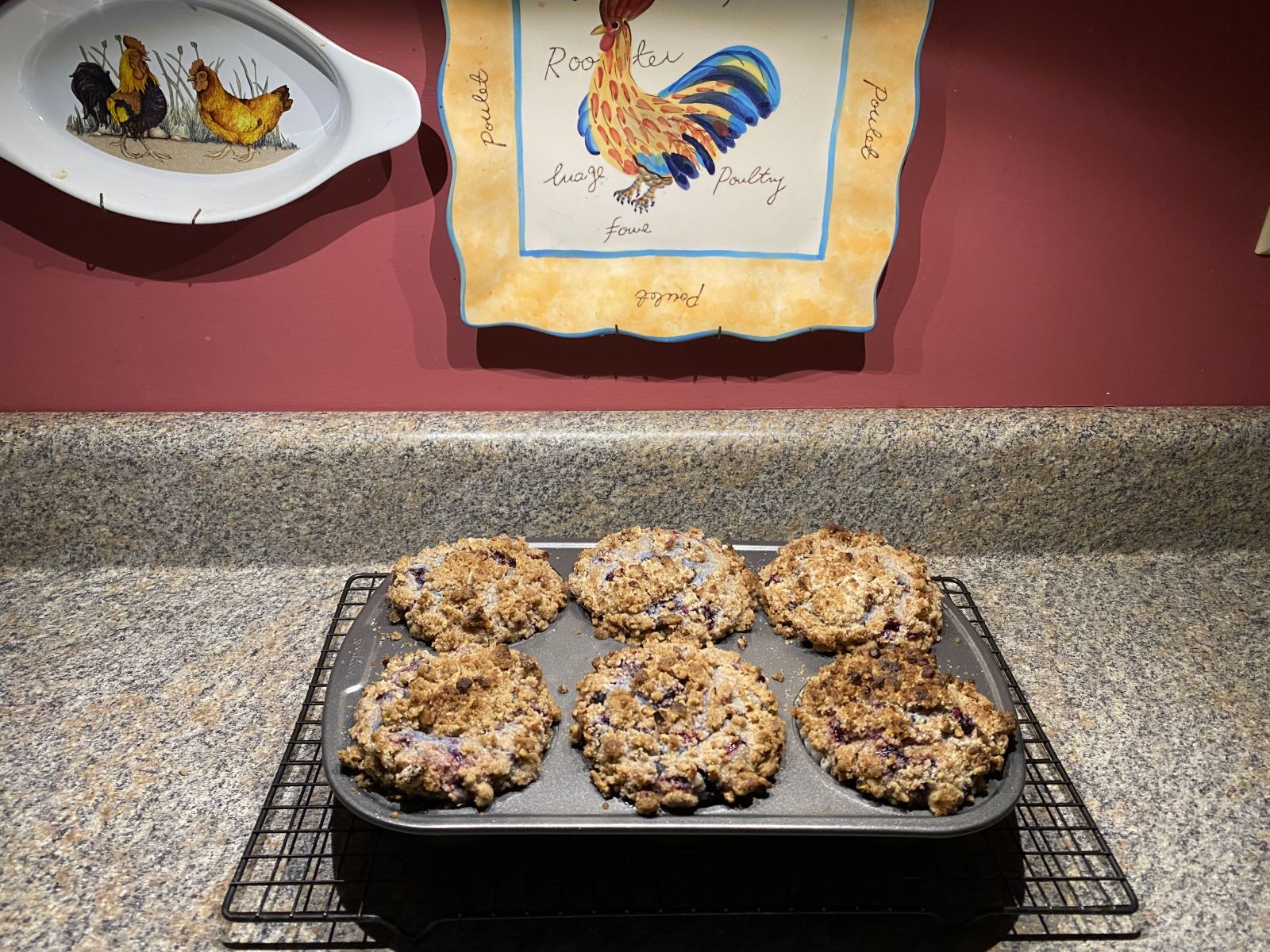 Extra-large blueberry muffins topped with crunchy pecan crumble on a cooling rack.
