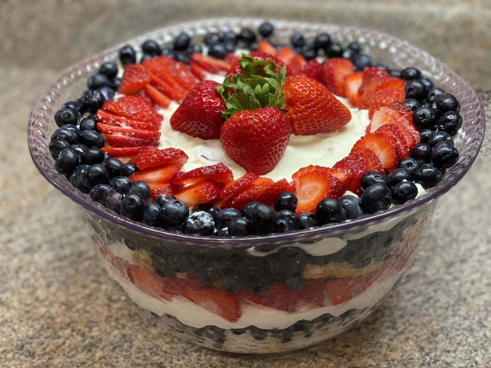 Patriotic berry trifle with layers of cake, cream, strawberries, and blueberries