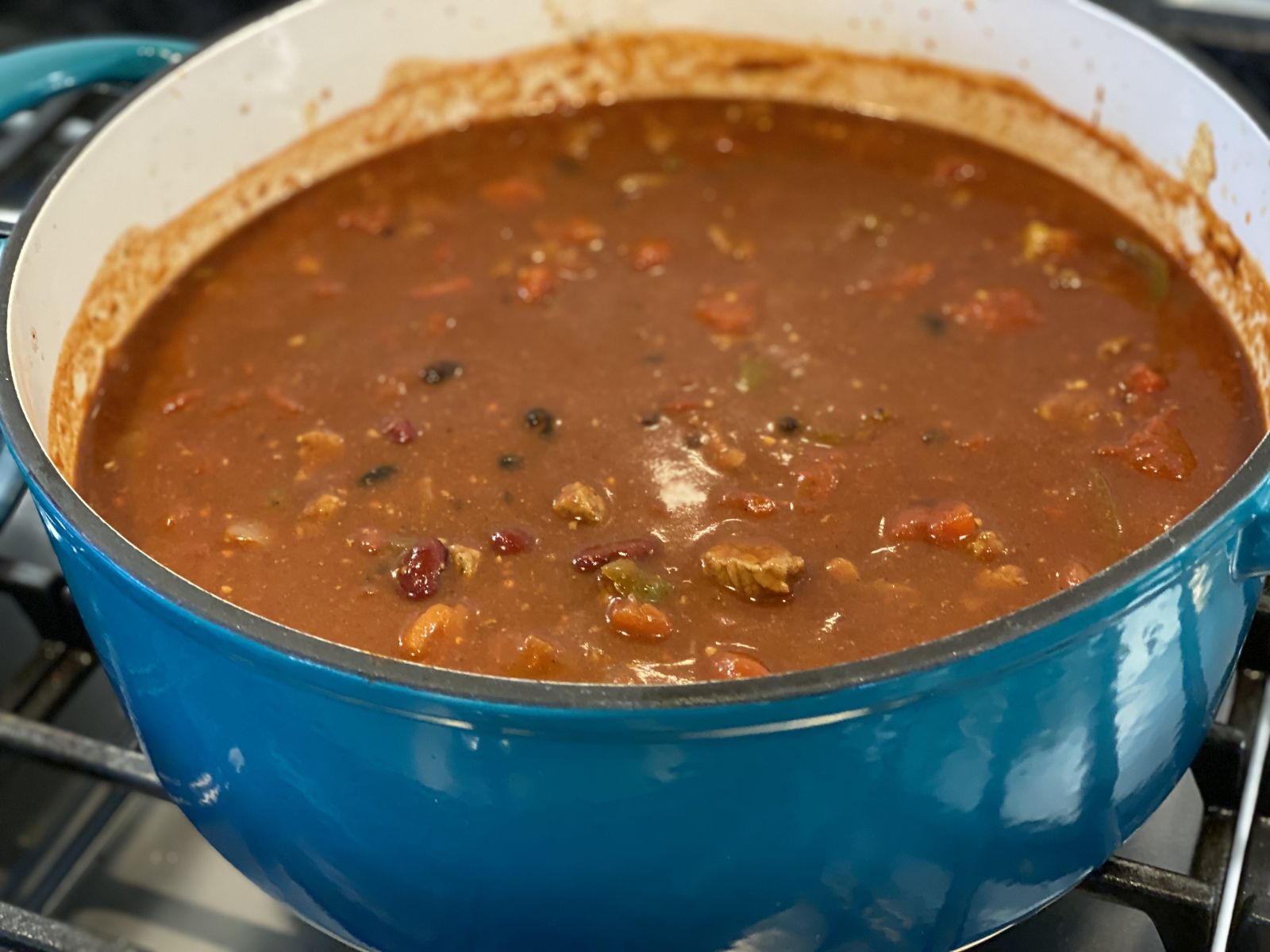 A hearty bowl of roast beef chili topped with cheese and sour cream.