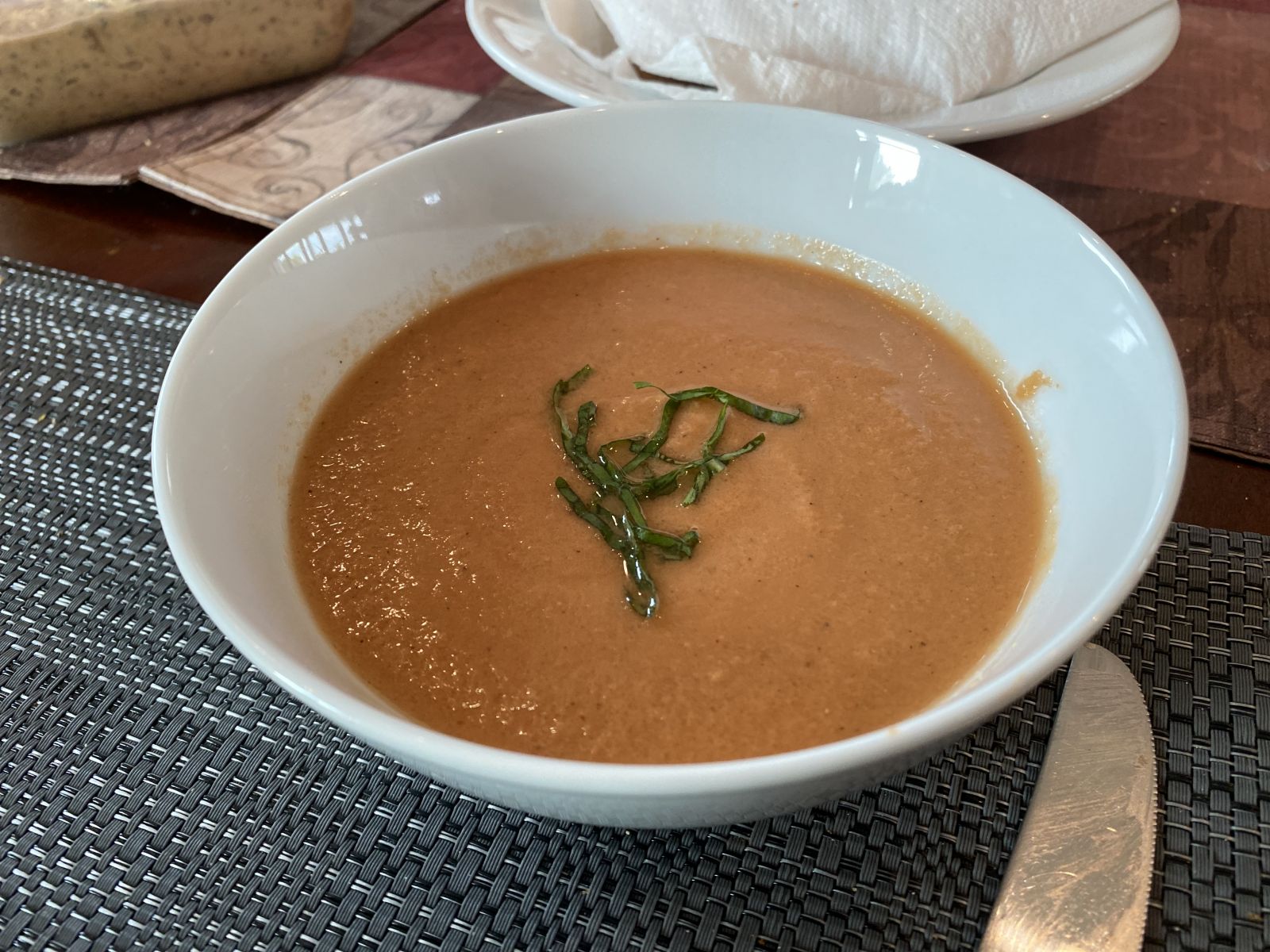 A chilled bowl of gazpacho garnished with basil chiffonade.