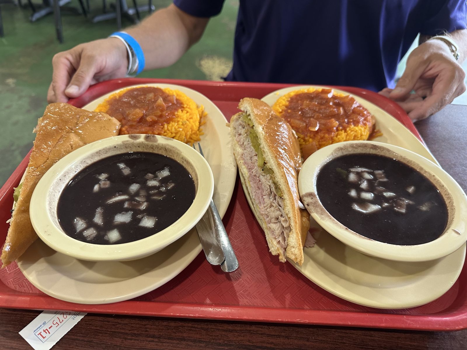 A bowl of hearty black bean soup topped with sour cream, avocado, cilantro, and tortilla strips.